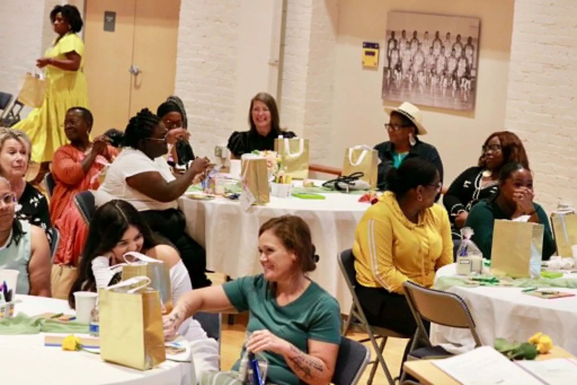 Workshop attendees laughing with gift bags at their tables