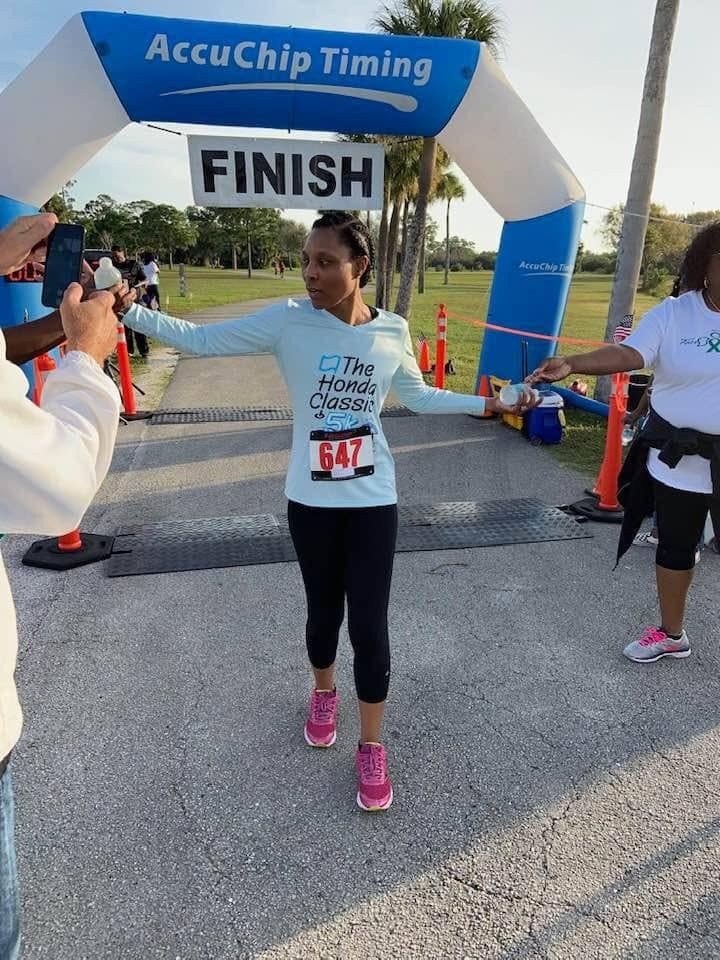 Camisha crossing a race finish line