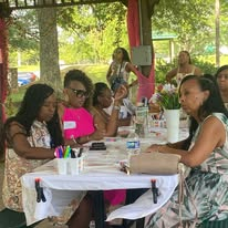 Women seated together at an outdoor community gathering