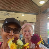 Camisha holding fresh flowers with a friend