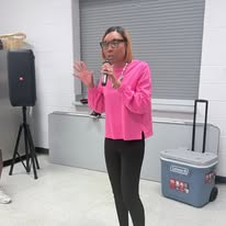 Camisha speaking with a microphone at a community workshop